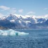 An iceberg in the Columbia Bay, with the mountains of the Chugach National Forest.. Climate Pivot Photo: Rich Miller