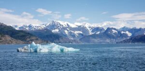 An iceberg in the Columbia Bay, with the mountains of the Chugach National Forest.. Climate Pivot Photo: Rich Miller